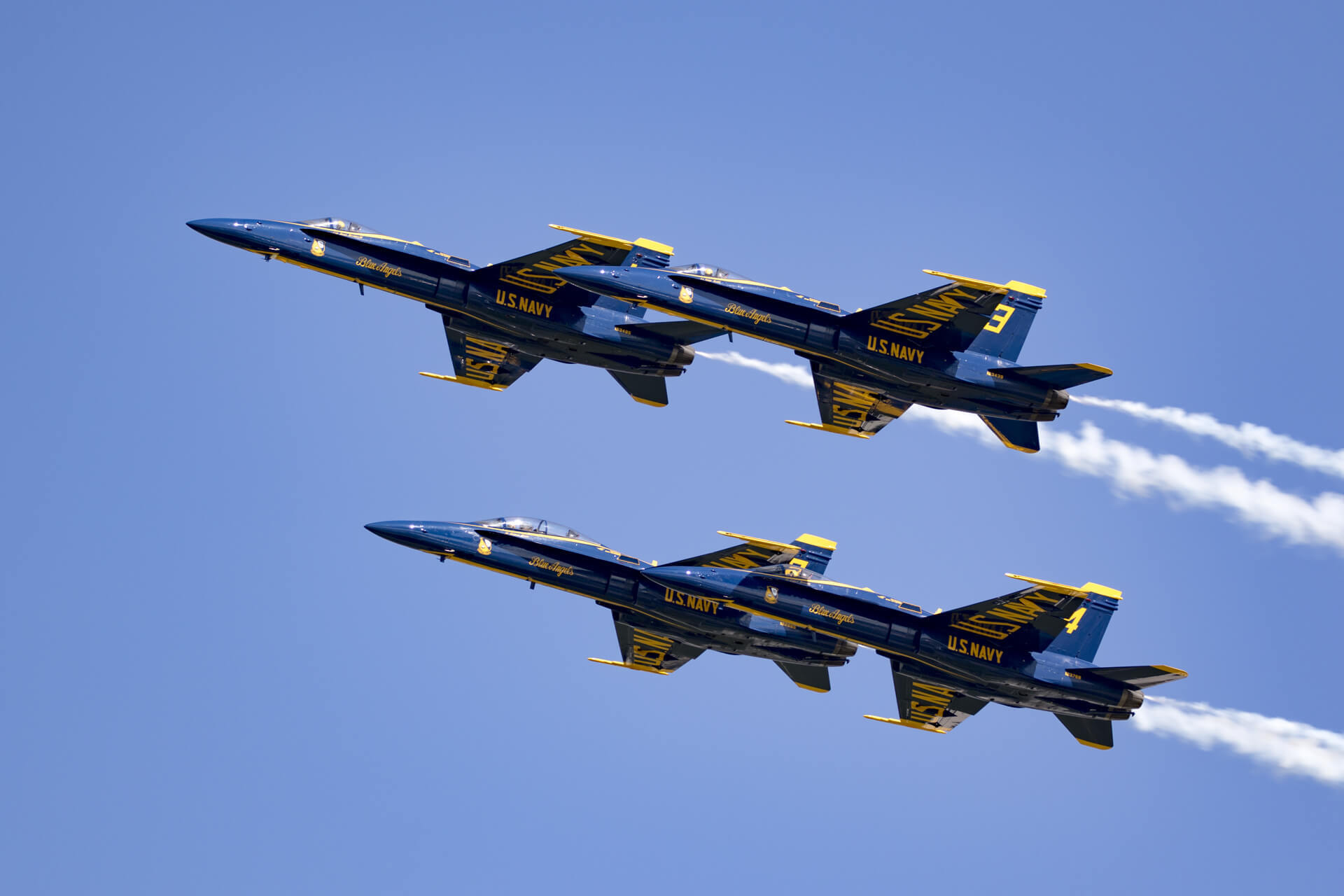 U.S. Navy Blue Angels flying in a close diamond formation.