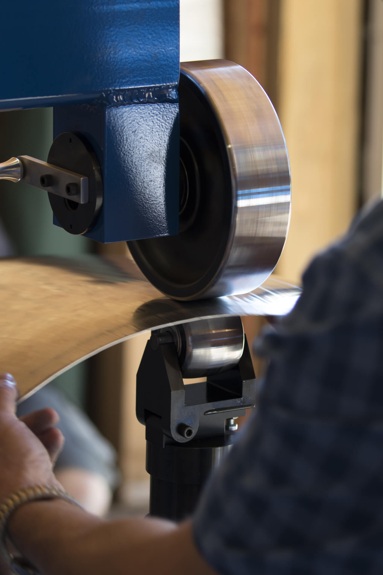 David Wenlarz shaping metal on an English Wheel in the Vintage Red Barn at AirVenture 2017.