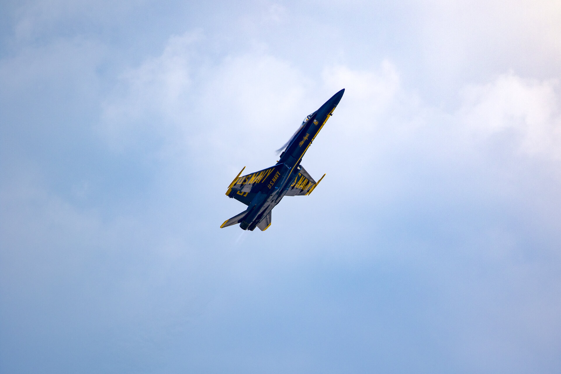 Blue Angel flying level at a reduced speed, with its nose pointed up.