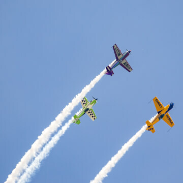Michael Goulian (green), Matt Chapman (yellow), and Bill Stein (purple) flying together at AirVenture 2017.