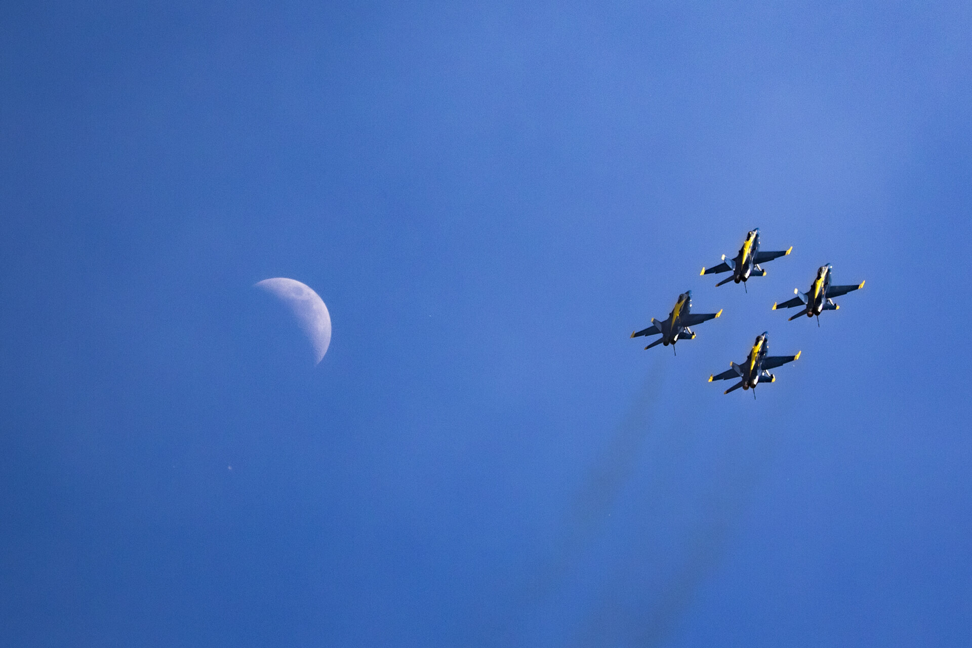 Blue Angel squadron flying in formation with the Death Star (moon) in frame.