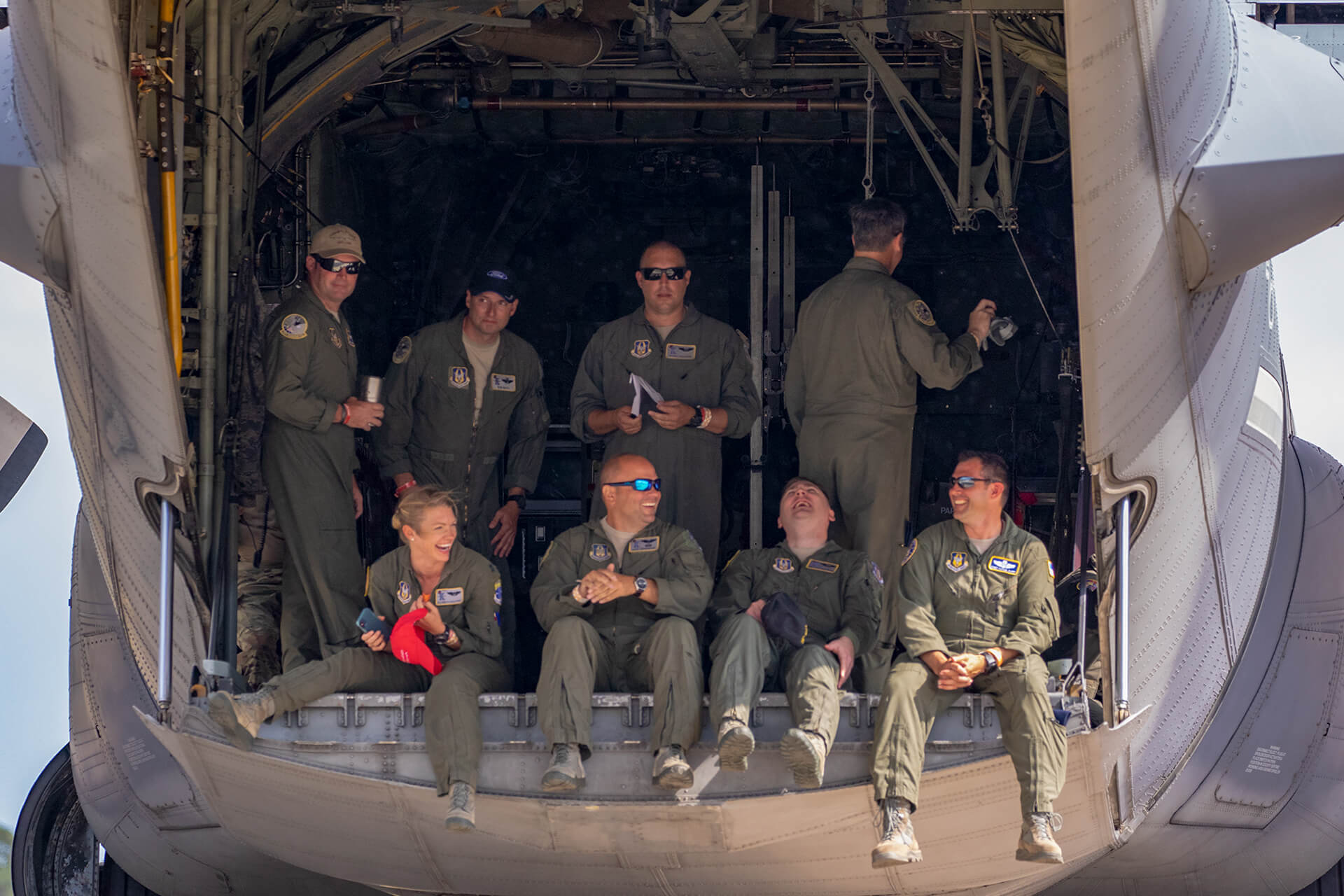 Airmen enjoying themselves, hanging out the back of a Lockheed HC-130N Hercules.