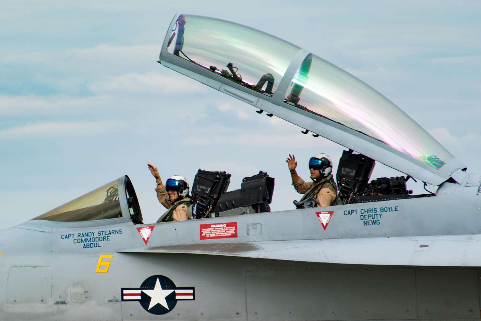 Navy pilots wave after landing their Super Hornet.