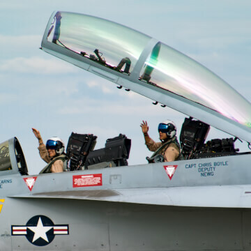 Navy pilots wave after landing their Super Hornet.