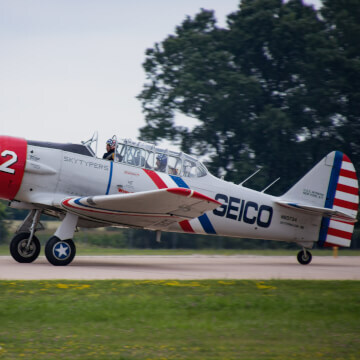One of the Geico Skytypers do a drive by after landing their T-6 Texan SNJ-2.