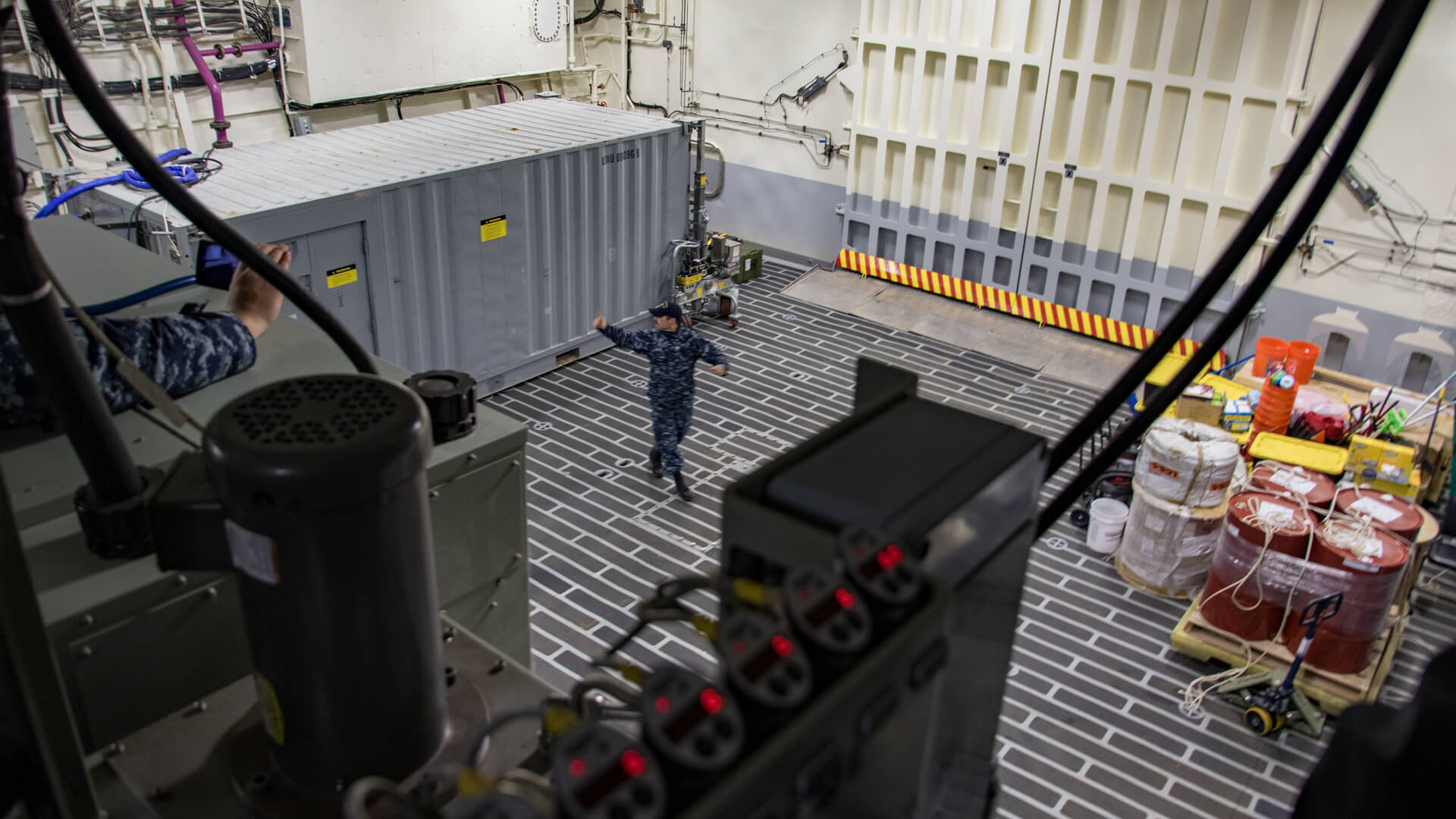 Navy personnel explaining the mission bay of the USS Milwaukee.